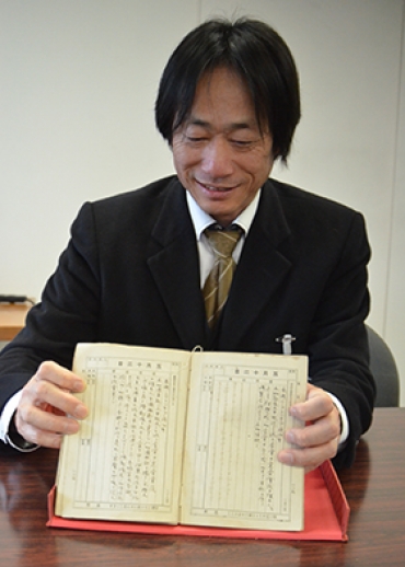 中川さんが書いた日記を手にする岩瀬専門員=豊橋市役所で