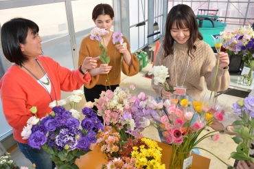 摘みたての花を手にミニブーケを作る女子大生ら=田原市堀切町で