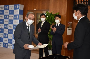 竹本市長から市政功労表彰を受ける前市長の山脇さん㊧=豊川市役所で