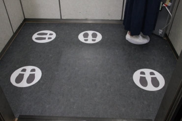 エレベーター室内の床に貼った足跡マーク=いずれも豊橋市役所で