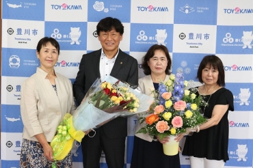天野会長㊧らローズメイトから花束を贈られた竹本市長(左から2人目)(JAひまわり提供)