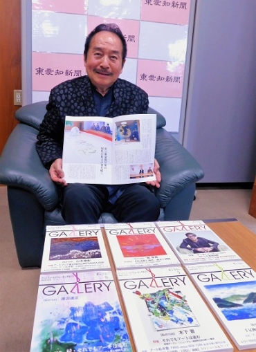 自身が登場する神社年鑑を手に、近況を報告する松井さん=東愛知新聞社で