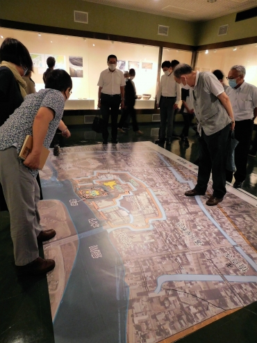 床に展示された「近世吉田城の構造と現存遺構」を見る内覧会出席者