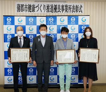 表彰状を持つ鈴木社長、鈴木寿明市長、市川社長、小山社長(左から)
