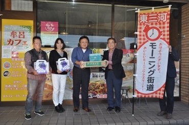 中村会長(右端)から記念品を受け取る左から中尾さん、鈴木夫妻=牟呂カフェで