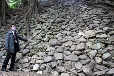 石垣に用いられた石の境界を棒で示す学芸員=豊橋市の吉田城跡で