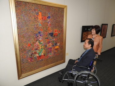 市川氏の作品「宇宙への通信」と甥の明さん夫妻=桜ヶ丘ミュージアムで