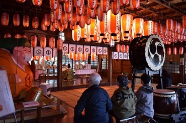 天井に飾られた多くの提灯の下、祈とうを受ける人たち=砥鹿神社の三河えびす社で