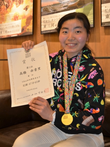 東京マラソン優勝の賞状とメダルを手に笑顔の高橋さん。=豊橋市内で