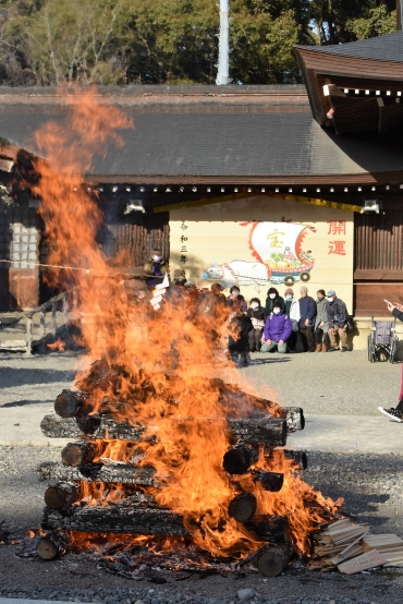 今年の干支の丑(うし)と宝船を描いた絵馬を背に燃え上がる炎=砥鹿神社で