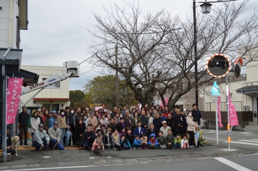 長年親しんだサクラの木をバックに記念写真を撮る集まった住民ら=豊橋市大岩町で