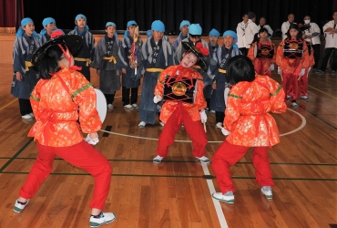 ヤンヨウ神役の男児(後方)が囃子を歌う中、笹踊りを舞う女児=牛久保小学校で