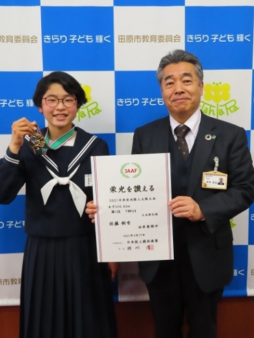メダルを片手に笑顔の佐藤さん㊧と鈴木教育長