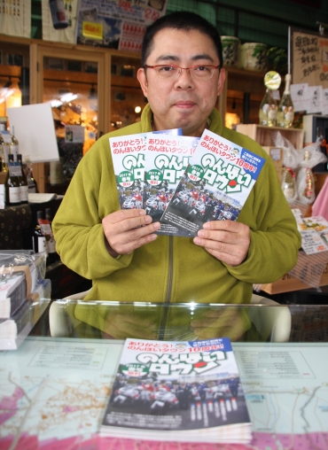 「のんほいタウン」創刊10周年号を手にする藤本さん=新城市内で
