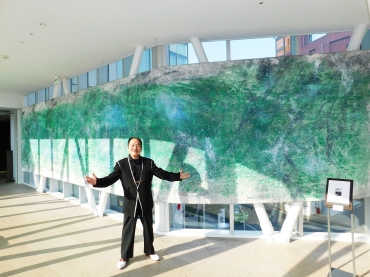 渡仏50周年記念個展開催中の松井氏。後方は新作「葵グリーン」=ホテルアークリッシュ豊橋で