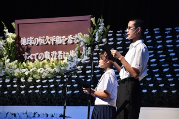 戦争と平和の詩を朗読する金屋中学校の生徒ら=いずれも豊川市文化会館で