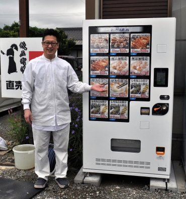 冷凍食品を販売する自動販売機「ど冷えもん」と北澤社長=さくらFOODSで