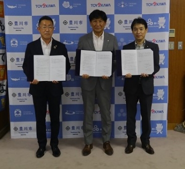 調印した小山支配人、竹本市長、池田副市長(左から)