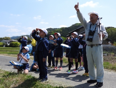 権田さん㊨と共に野鳥を観察する児童ら=萩町内で