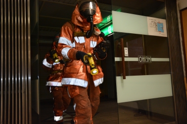 ガス濃度を確認しながらビル内で要救助者を探す消防隊員=名豊ビルで