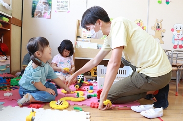 研修先で園児らとおもちゃ遊びに興じる新人職員=牛川東保育園で
