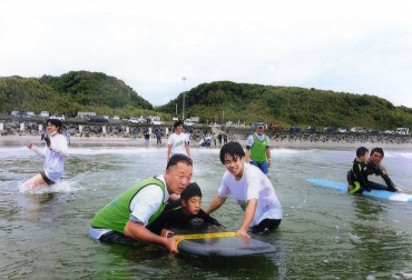 サーフボードに乗って楽しむ子ども=田原市若見町で(提供)