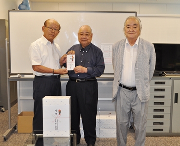 ペットボトルの贈呈式(左から黒柳社長、井上会長、倉橋監事)